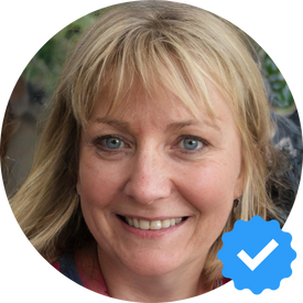 A smiling woman named Emily W., a satisfied customer of Hellamaid cleaning services, sharing her positive experience after preparing her home for a family reunion.