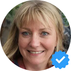 A smiling woman named Emily W., a satisfied customer of Hellamaid cleaning services, sharing her positive experience after preparing her home for a family reunion.