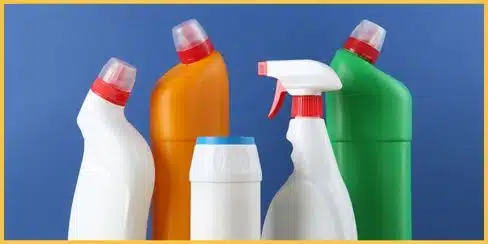 Variety of cleaning products bottles with a blue background.
