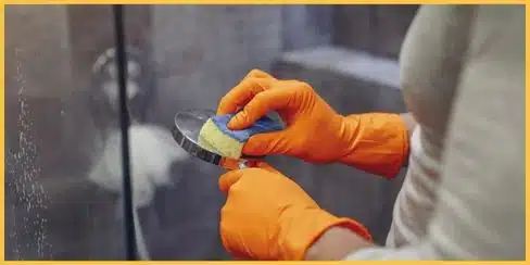 A professional cleaner in Canada cleaning the shower.