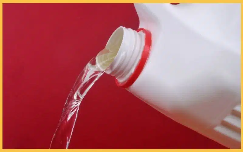 A bottle pouring out liquid bleach.