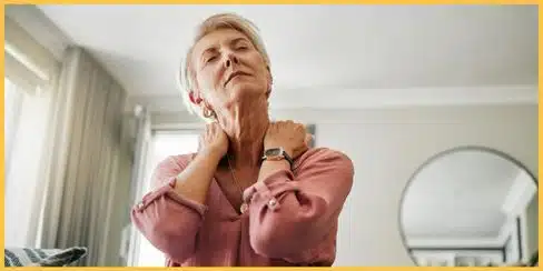 A woman holding her neck, appearing to be in pain.