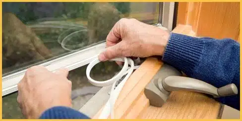 Hands applying window sealers to prevent fleas from entering through gaps in the house.