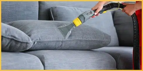 Cleaning professional vacuuming a couch.