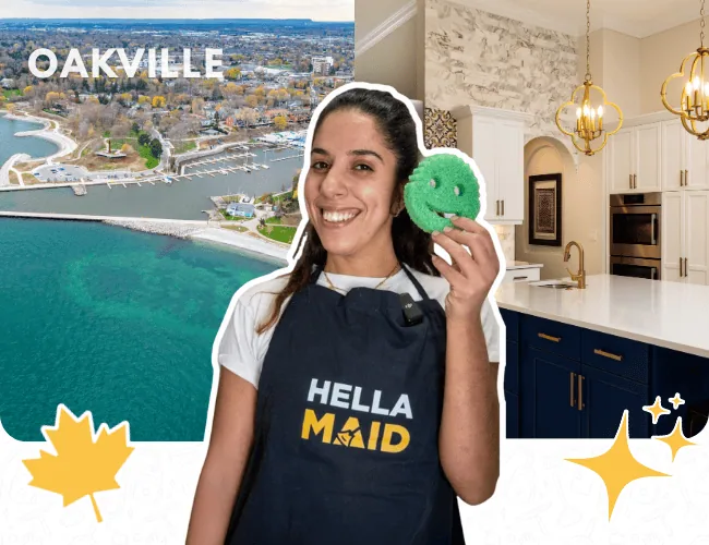Hellamaid cleaner in Oakville, holding a scrubber and smiling, with a modern kitchen and scenic view of the waterfront