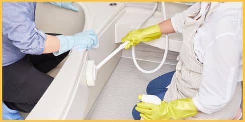 Professional cleaners in Toronto cleaning a bathroom's bathtub.