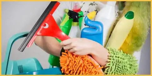 A person holding a bucket and cleaning tools.