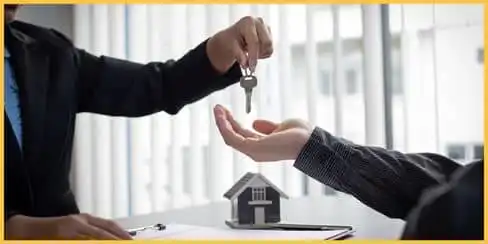 A landlord and tenant exchanging house key.