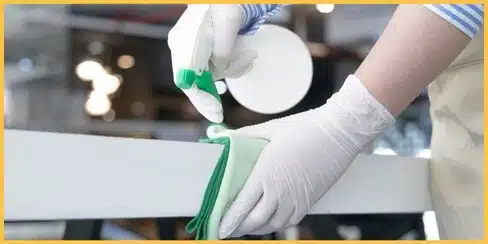 A professional cleaner in Ottawa wiping the table's edges.