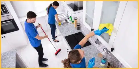 Professional cleaners tidying up a kitchen.