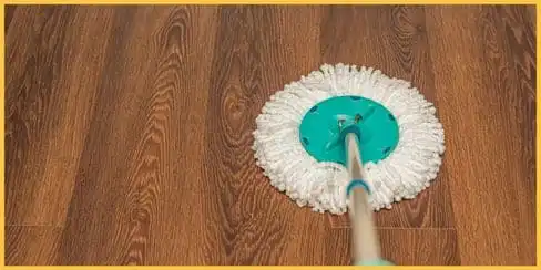 A professional cleaner is mopping a laminated floor.
