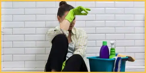 A cleaner sitting on the floor looking tired.