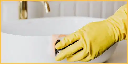 A Hellamaid cleaner in Surrey cleaning a sink.