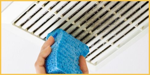 Professional cleaner in Canada using a sponge to clean the fan.