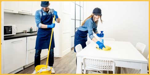 Professional cleaners tidying up a kitchen area.