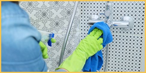 Cleaning lady wiping off the stains on a faucet.