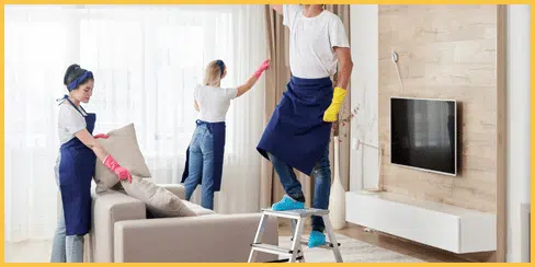 The cleaners of Hellamaid, a top-rated cleaning company in Canada, tidying a living room.