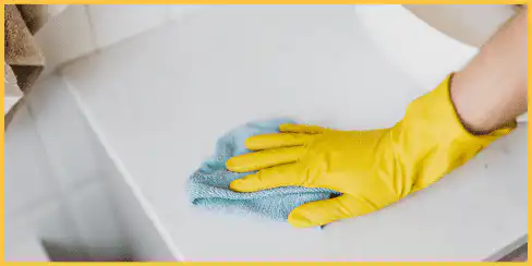 Gloved hand wiping a countertop.