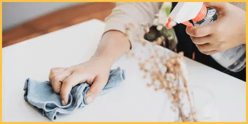 A cleaner wiping a table.